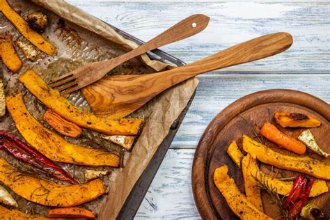 Rodajas De Calabaza Asadas Y Verduras Horneadas En Placa De Madera Foto