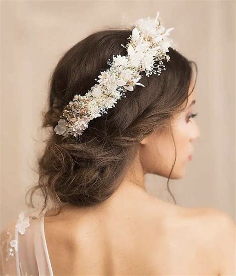 A Woman Wearing A White Flower Headpiece With Flowers In Her Hair