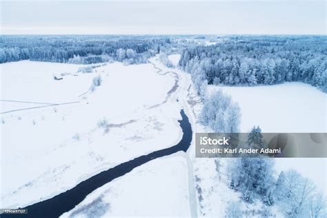 Aerial Of A Frosty And Snowy Rural Landscape With A Open River In