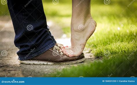 Lady Standing Barefoot On Tip Toes On Her Lovers Shoes Stock Image