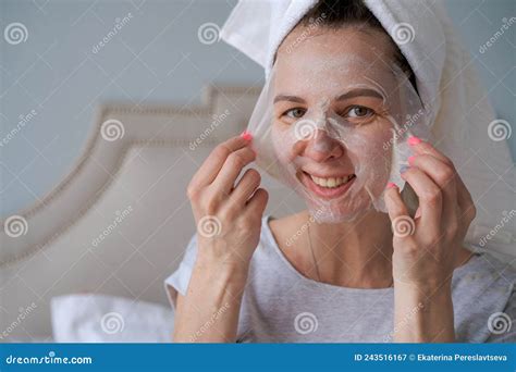 Nice Woman With Towel On Her Head Applies Moisturizing Mask To Her Face Stock Image Image Of