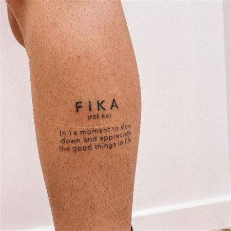 "FIKA" lettering tattoo on the calf.