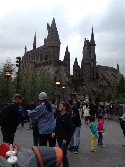 people are walking around in front of hogwarts castle