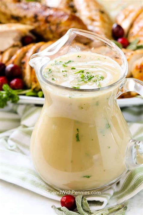 A Glass Pitcher Filled With Dressing Sitting On Top Of A Table Next To