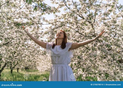 Fantasy Woman In Long White Elegant Fashion Long Dress Walks In Green Spring Blossom Cherry