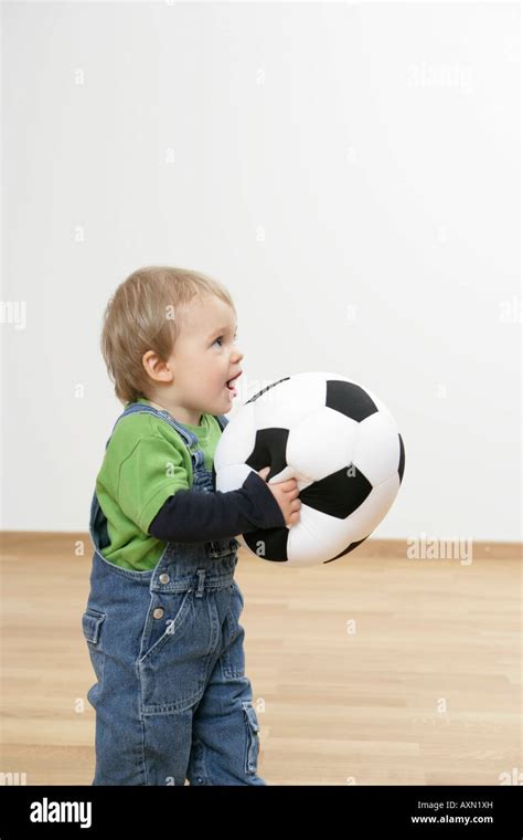 Baby boy holding a football Stock Photo - Alamy