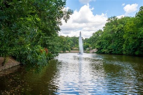 Premium Photo Scenic Lake With A Fountain In The Center Among The