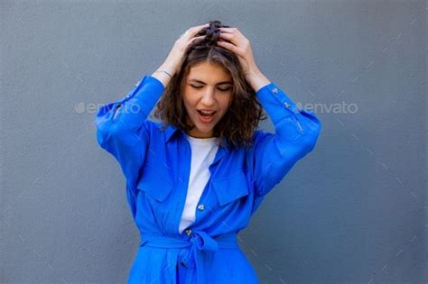 Candid Portrait Of Beautiful Woman In Blue Jacket On Grey Background