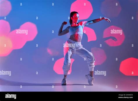 Full Body Of Young Female Dancer In Sportswear Dancing In White Studio