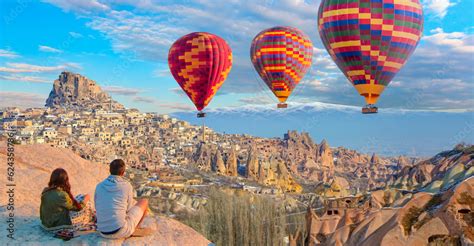 Hot Air Balloon Flying Over Spectacular Cappadocia A Couple Watching The Hot Air Balloon At