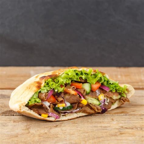 Doner kebab doner kebap comida rápida en pan plano en un tablero de