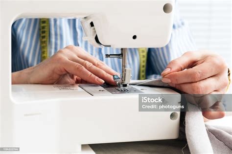 Closeup Partial View Of Seamstress Working With Sewing Machine And