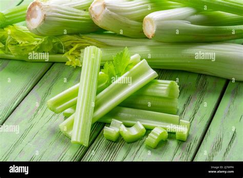 Pile of celery ribs on green wooden table. Healthy food background ...