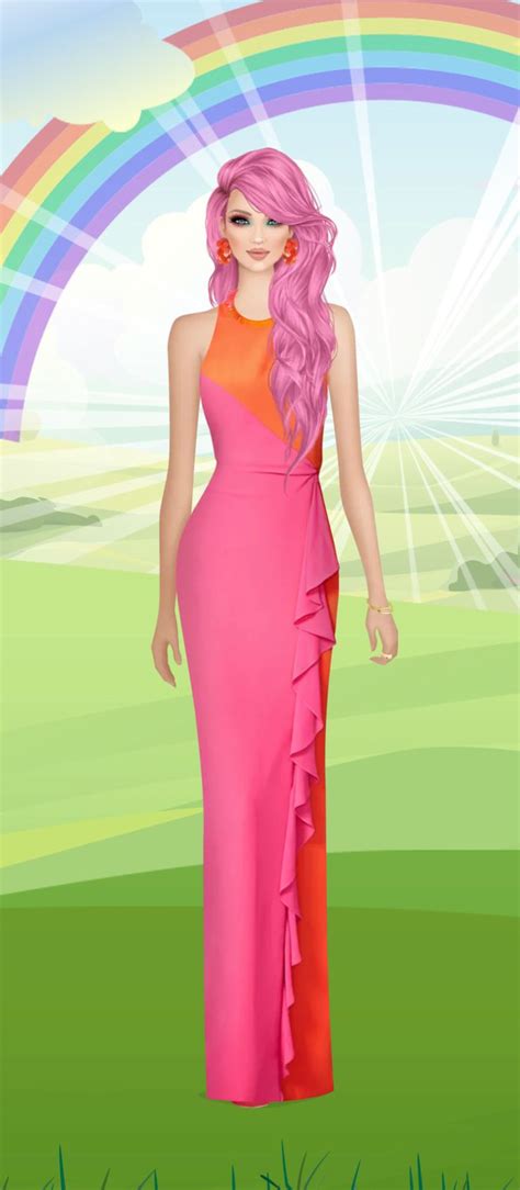 a woman in a pink dress standing on grass with a rainbow in the sky ...