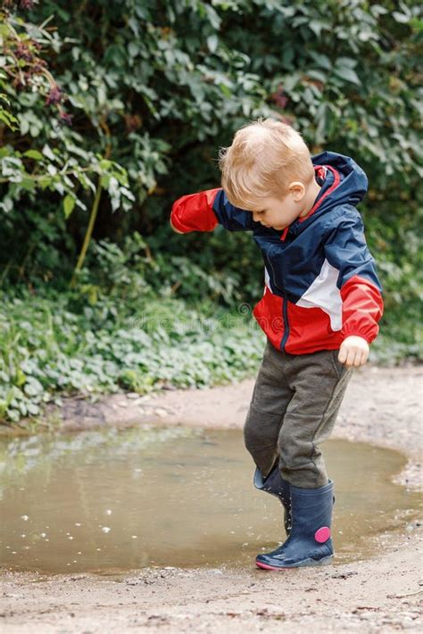 Toddler Jumping In Pool Of Water At The Summer Or Autumn Day Stock