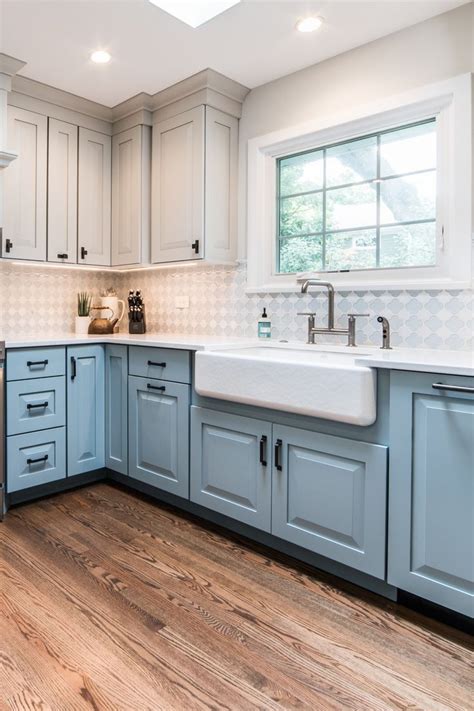 Blue Cabinets With White Countertops And Glass Backsplash Tiles