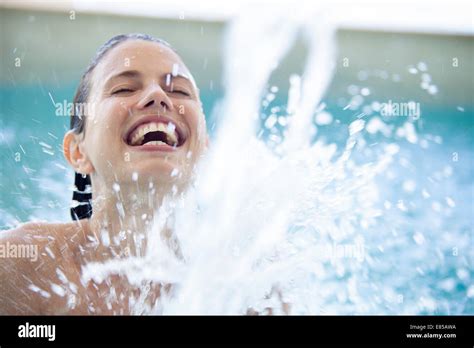 Woman Splashing In Pool With Eyes Closed Stock Photo Alamy