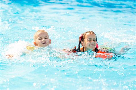 Gar On Souriant Et Petite Fille Nageant Dans La Piscine Du Parc