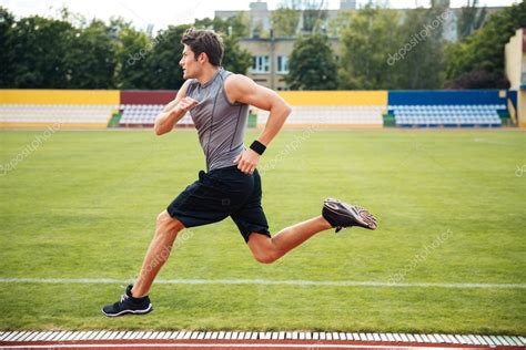 Vista Lateral De Un Velocista Corriendo En Pistas De Atletismo