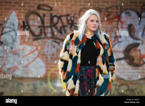 Urbane Lage Foto Modellierung eine junge Platinum Blonde Frau Mädchen steht vor einem Graffiti