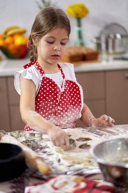 Niña haciendo galletas de jengibre en casa Foto Premium