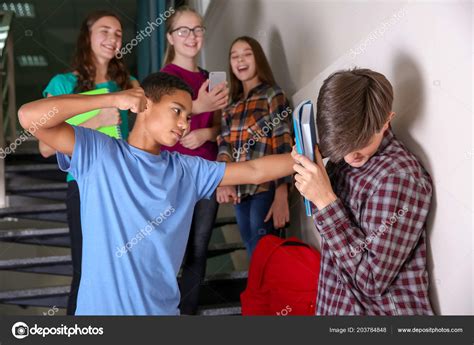 African American Boy Bullying Teenager Indoors Stock Photo by ...