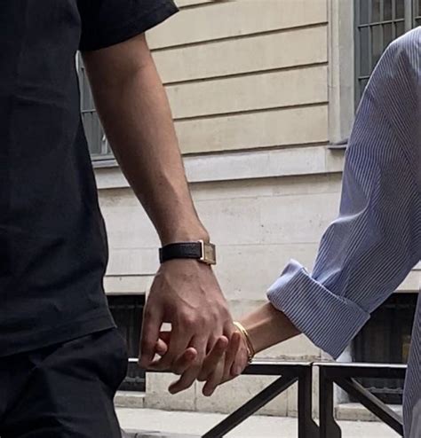 Two People Holding Hands While Standing Next To Each Other