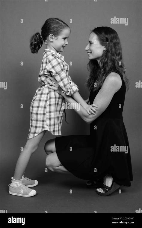 Mother and daughter bonding together against gray background Stock Photo - Alamy