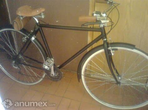 A Black Bicycle Parked In Front Of A Door Next To A Tiled Floor And Wall