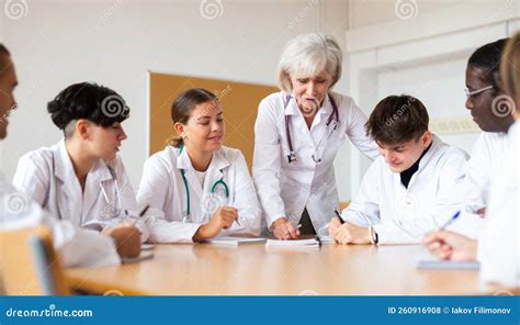 Medical Workers Listening To Aged Female Lecturer During Professional