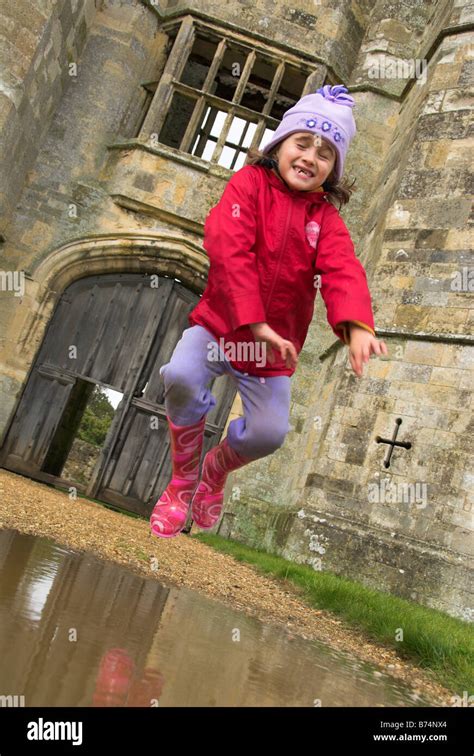 Little Girl Jumping In A Puddle Stock Photo Alamy