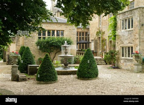 Water Fountain And Topiary In Courtyard Of Jacobean English Country