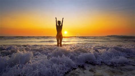 Femme Heureuse Dans Le Bikini Sautant Dans Le Coucher Du Soleil De Mer