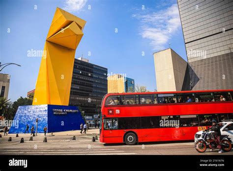 Metrobús passes by the yellow El Caballito statue by sculptor Enrique