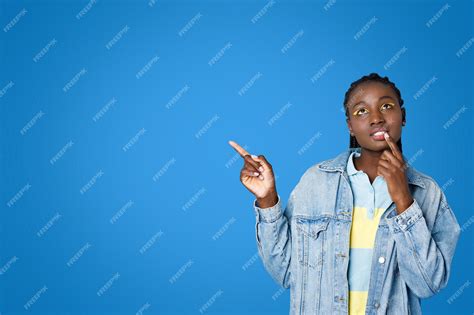 premium photo pensive young black woman touching lip  pointing