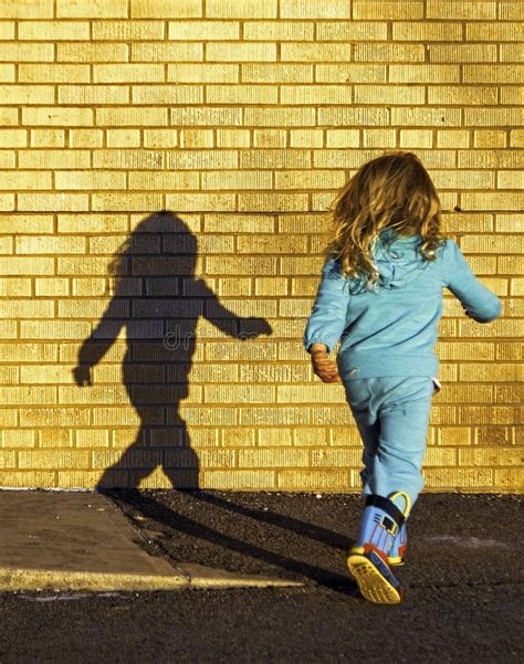 Young Girl Dancing With Her Shadow On A Playground Editorial Image