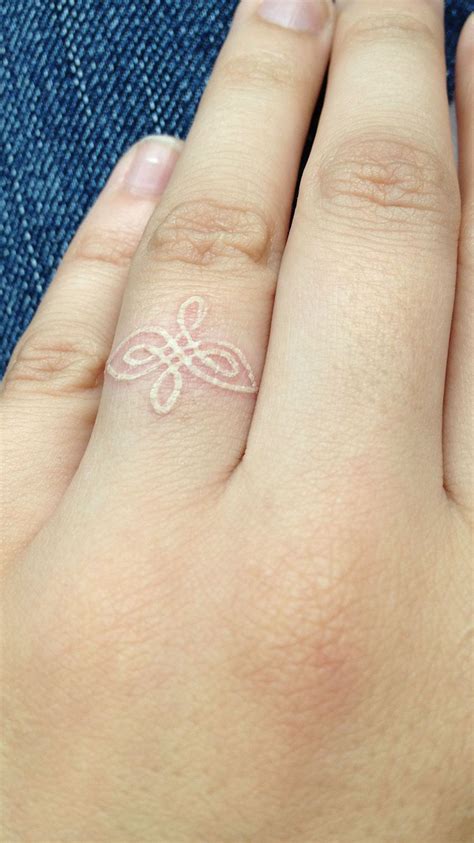 A Woman S Hand With A Small Tattoo On Her Left Ring And The Word Love