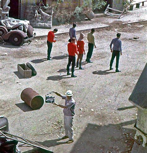 several men are standing in the dirt near an old truck and some ...