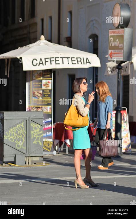 SMOKING – ITALIAN WOMAN SMOKING A CIGARETTE NEXT TO A CAFFETTERIA UMBRELLA LISTENING TO MUSIC ...