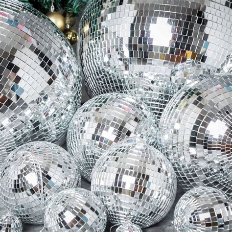 Many Shiny Disco Balls Sitting Next To A Christmas Tree