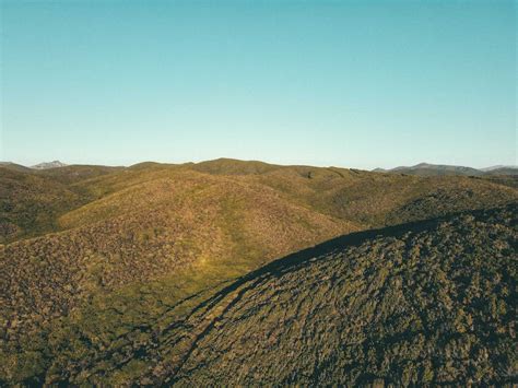 Hilly terrain on cloudy day at sunrise · Free Stock Photo