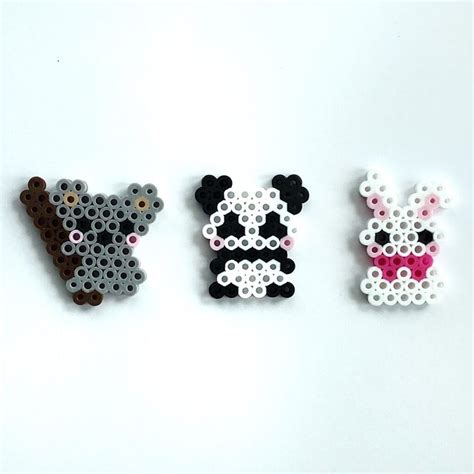 Three Pieces Of Perler Bead Art On A White Surface