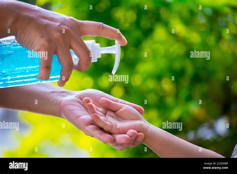 Blur Background Of Mother Cleaning Her Kids Hand With Alcohol Gel