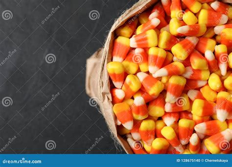 Paper Bag With Tasty Candy Corns On Dark Table Top View Stock Photo