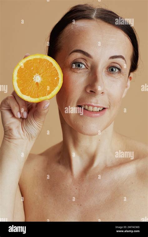 Portrait Of Happy Modern 40 Years Old Woman With Orange Isolated On