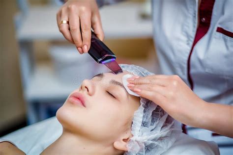 Woman Receiving Ultrasonic Facial Exfoliation At Cosmetology Salon