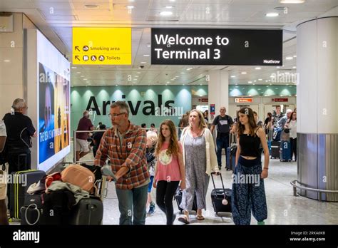 Passengers Arriving At London Heathrow Airport Terminal 3 Passing Out Into The Arrivals Lounge