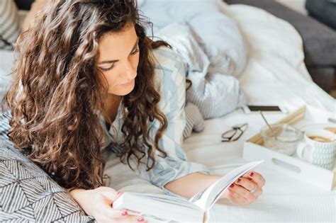 Premium Photo High Angle View Of Young Woman Reading Book While Lying