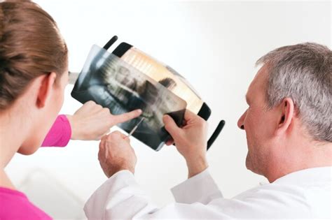 Premium Photo | Dentist explaining x-ray to patient