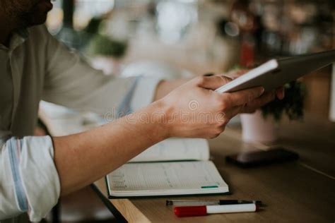 Person Taking Notes In A Notebook While Working From Home Stock Image